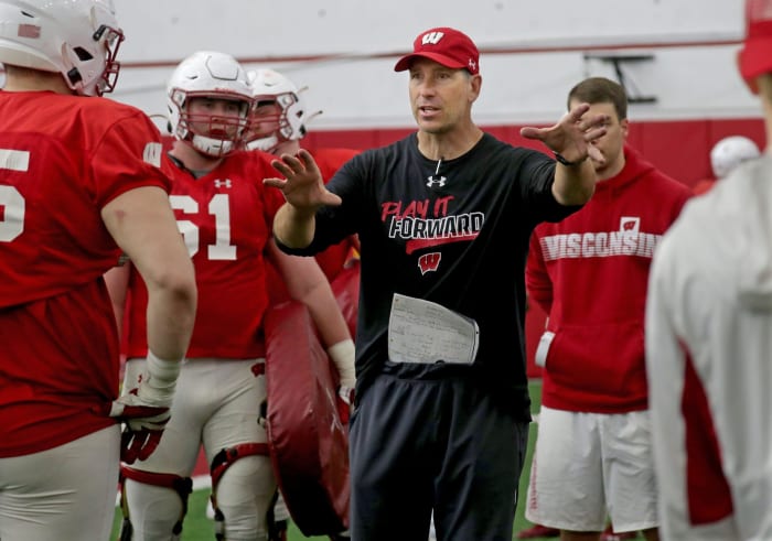 Offensive line coach Bob Bostad works with his players the during the University of Wisconsin spring football practice at Camp Randall Stadium in Madison on Thursday.